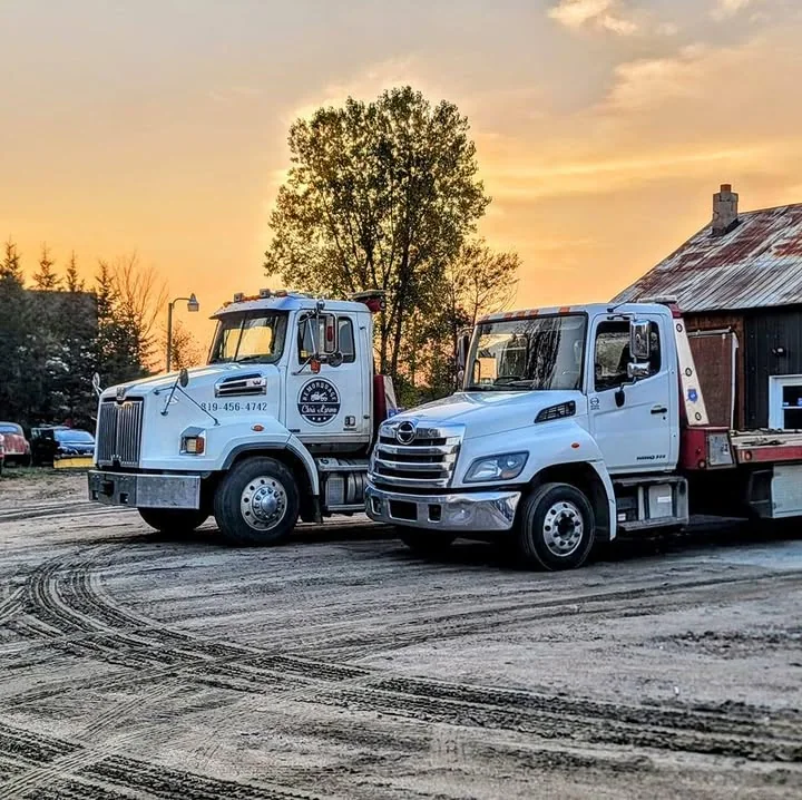 Deux dépanneuses Chris Larose stationnées au coucher du soleil